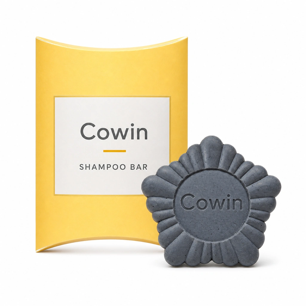 Cowin dark flower-shaped shampoo bar beside a yellow carton